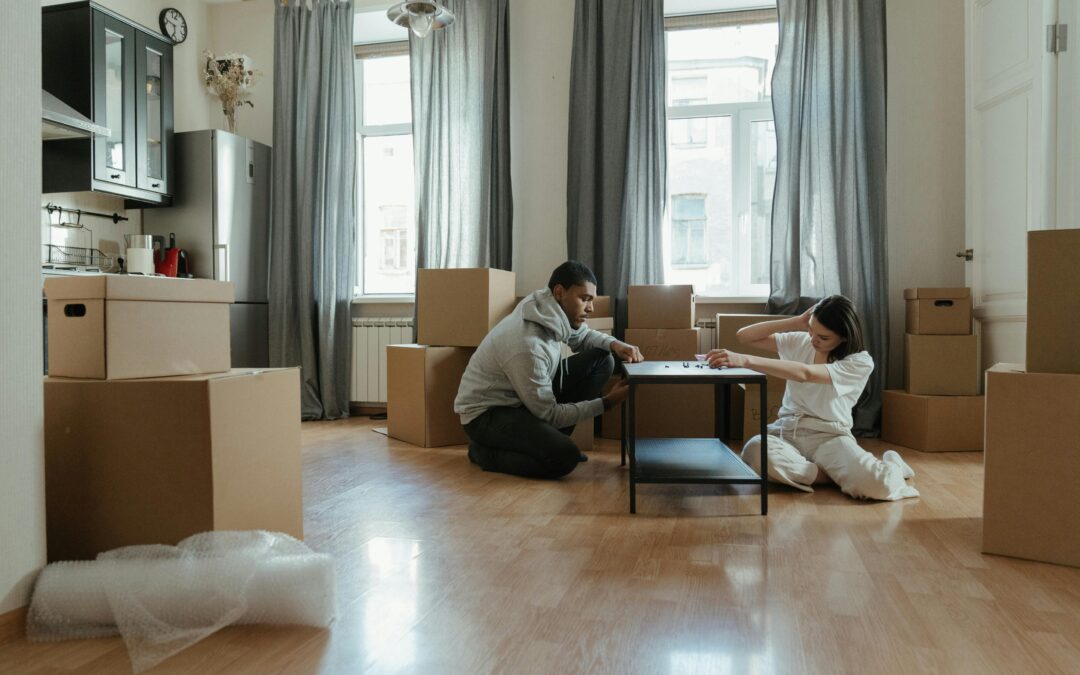 un couple qui monte une table basse dans leur premier appartement